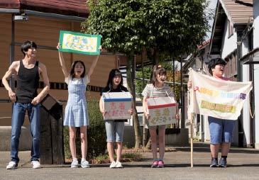 劇中シーン。衣装用の古着を集める子どもたち。